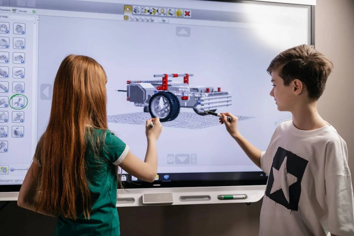 a girl and a boy understanding the robotics diagram of automobile